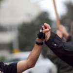 EPD officer and protester clasp hands. Photo by Tracy Sydor.