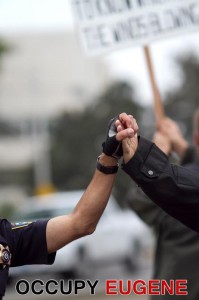 police officer and marcher clasp hands